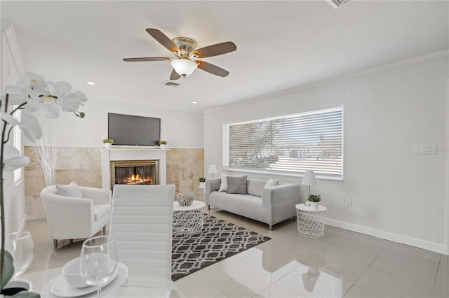 living area with tile patterned flooring, a fireplace, visible vents, and crown molding