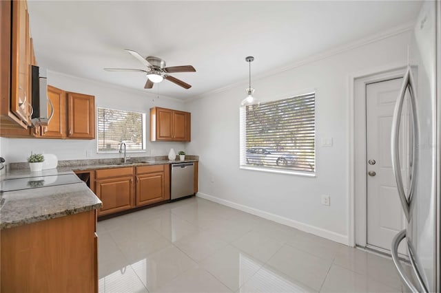 kitchen with baseboards, appliances with stainless steel finishes, brown cabinetry, and crown molding