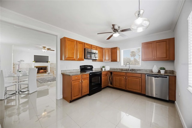 kitchen with brown cabinetry, ceiling fan, stainless steel appliances, and a sink