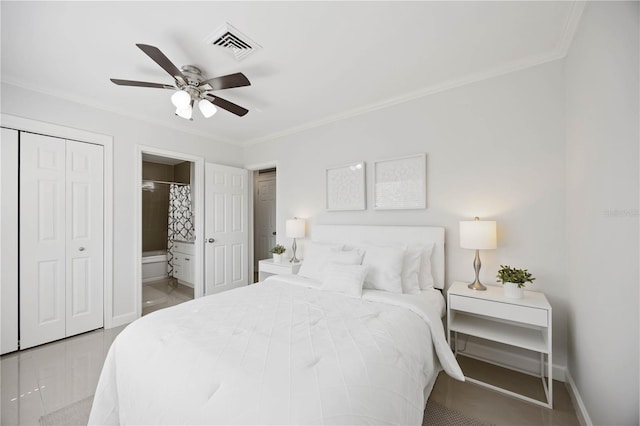 tiled bedroom featuring visible vents, baseboards, ornamental molding, a closet, and ensuite bath