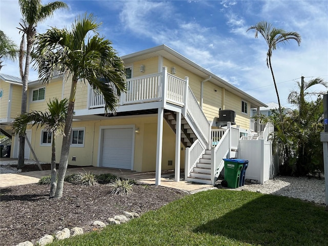 exterior space with driveway, stairway, an attached garage, and fence