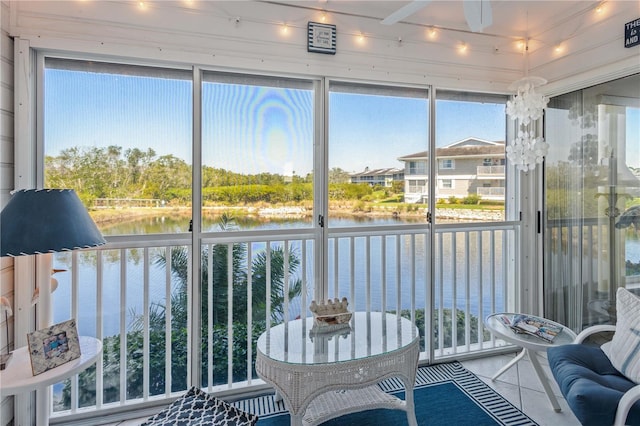 sunroom / solarium with a water view and a ceiling fan