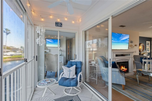 sunroom with visible vents, ceiling fan, and a high end fireplace