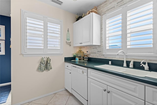 kitchen with dark countertops, visible vents, white cabinetry, white dishwasher, and a sink