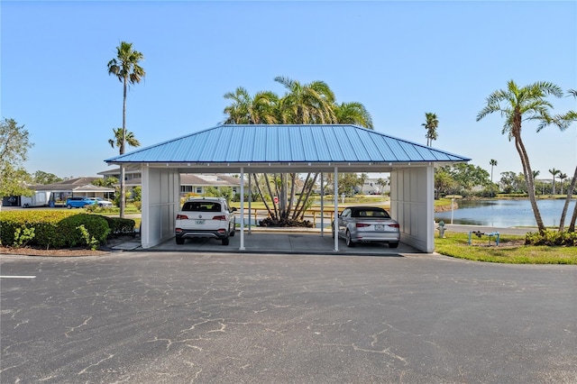 covered parking lot featuring a water view