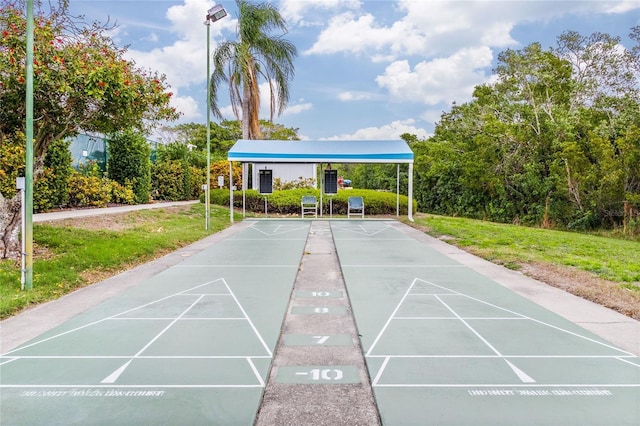 view of home's community with shuffleboard and a yard