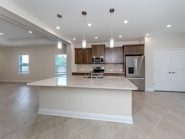 kitchen featuring dark brown cabinetry, light tile patterned floors, appliances with stainless steel finishes, a sink, and backsplash