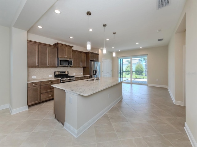 kitchen featuring a center island with sink, stainless steel appliances, recessed lighting, visible vents, and decorative backsplash