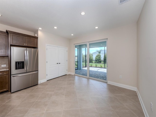 kitchen featuring recessed lighting, stainless steel refrigerator with ice dispenser, dark brown cabinetry, and baseboards