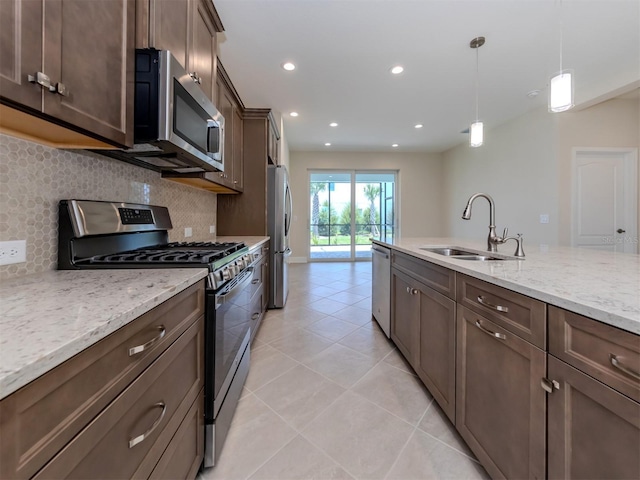 kitchen featuring backsplash, pendant lighting, stainless steel appliances, and a sink