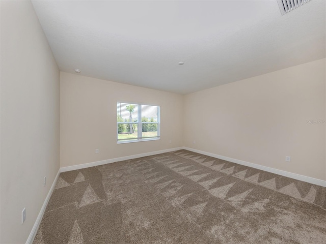 empty room featuring carpet, visible vents, and baseboards