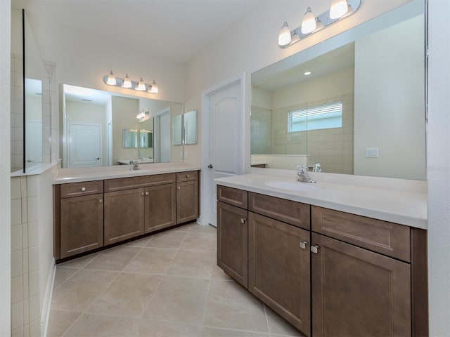 full bathroom featuring tile patterned flooring, two vanities, a sink, and a walk in shower