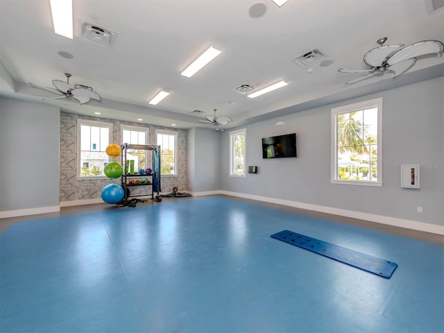 exercise area featuring visible vents, ceiling fan, and baseboards