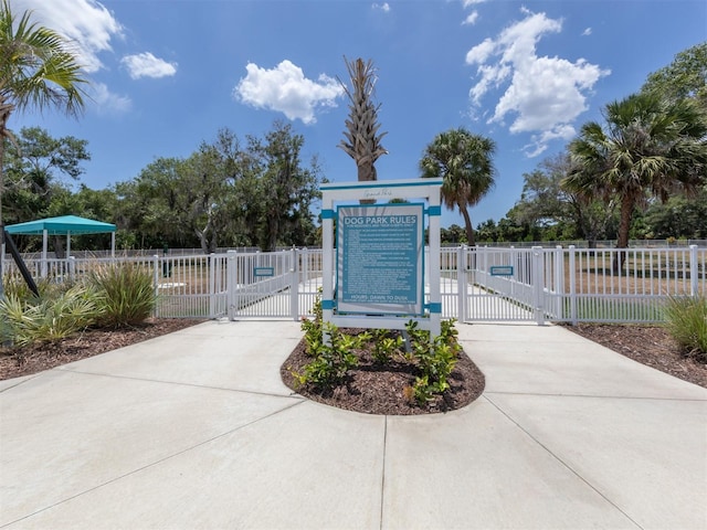 view of property's community featuring fence and a gate