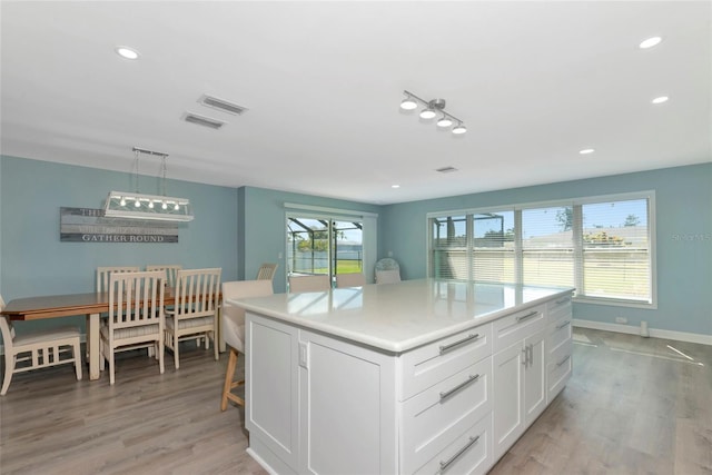 kitchen with light wood-type flooring, white cabinetry, and recessed lighting