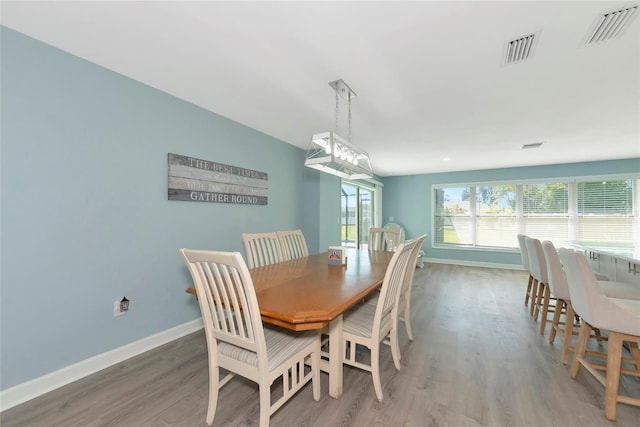 dining area featuring baseboards, visible vents, and wood finished floors