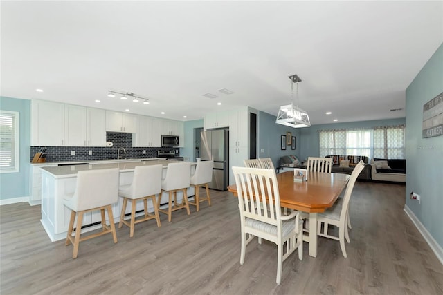 dining space with light wood-type flooring, baseboards, and recessed lighting