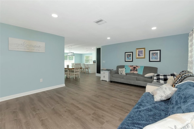 living area featuring recessed lighting, visible vents, baseboards, and wood finished floors