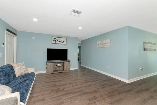 living room with recessed lighting, visible vents, baseboards, and wood finished floors