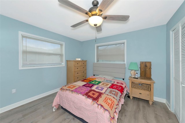 bedroom featuring a closet, wood finished floors, and baseboards