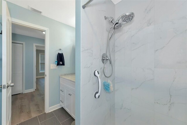 full bathroom with visible vents, a marble finish shower, vanity, and baseboards