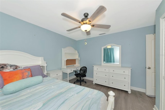 bedroom featuring a ceiling fan, baseboards, visible vents, and wood finished floors