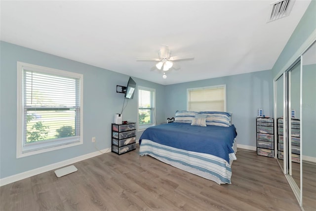 bedroom featuring a closet, visible vents, light wood finished floors, and baseboards