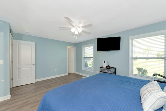 bedroom with a ceiling fan, baseboards, and wood finished floors