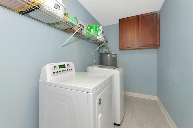 washroom with cabinet space, light tile patterned floors, baseboards, water heater, and separate washer and dryer