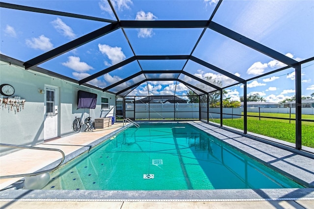 view of pool featuring glass enclosure, a fenced backyard, a patio, and a lawn