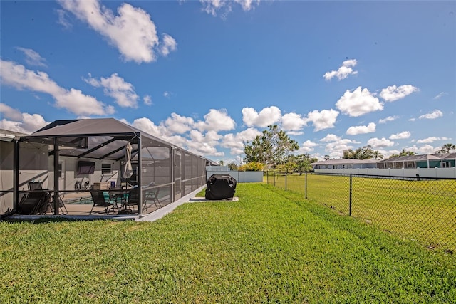 view of yard featuring a lanai, a patio area, fence, and a fenced in pool