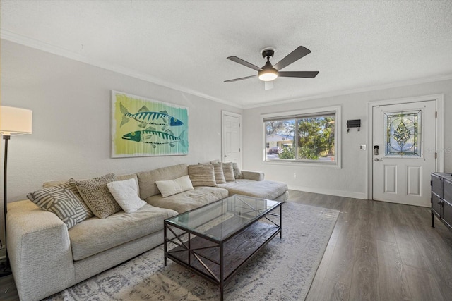 living area with ornamental molding, a ceiling fan, a textured ceiling, baseboards, and hardwood / wood-style flooring