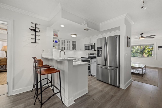 kitchen featuring a peninsula, visible vents, white cabinets, appliances with stainless steel finishes, and glass insert cabinets