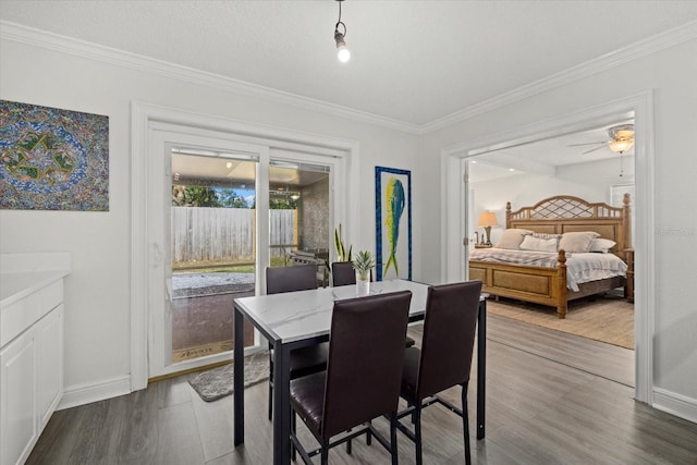 dining room with baseboards, ornamental molding, and wood finished floors