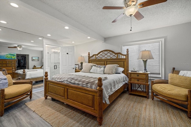 bedroom with a ceiling fan, beamed ceiling, wood finished floors, a textured ceiling, and recessed lighting