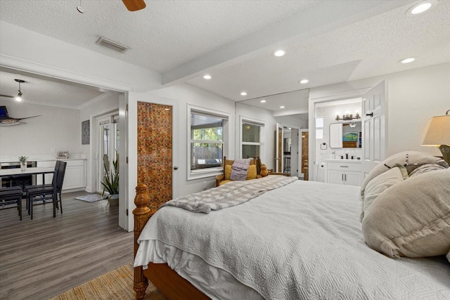 bedroom with a textured ceiling, visible vents, wood finished floors, and recessed lighting