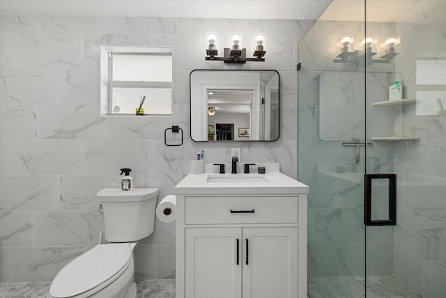 bathroom with a stall shower, toilet, an inviting chandelier, vanity, and tile walls