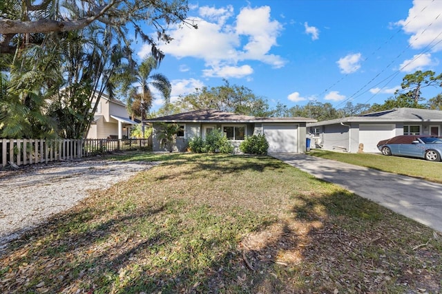 ranch-style house featuring driveway, a garage, fence, and a front yard