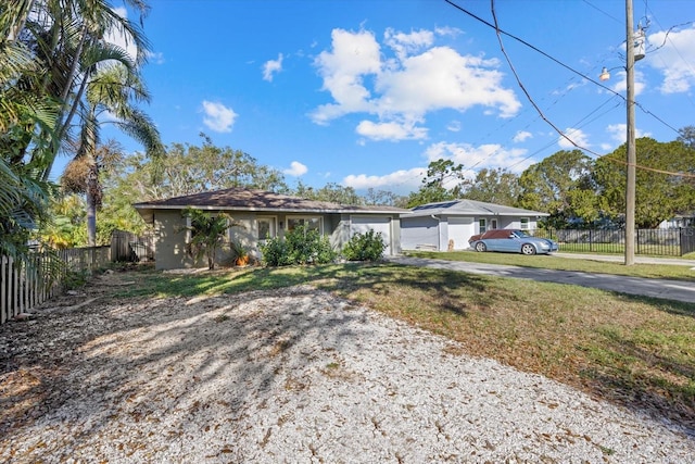 ranch-style house featuring a garage, fence, and driveway