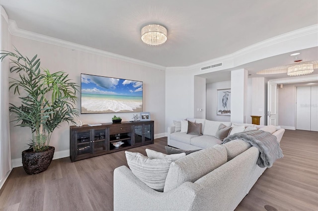 living room with crown molding, visible vents, and wood finished floors