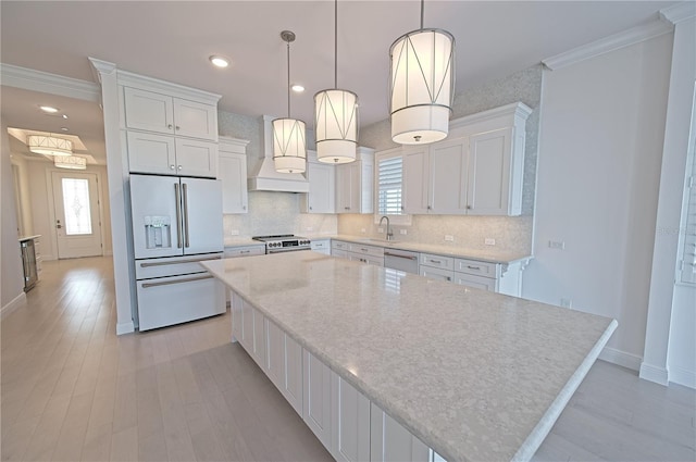 kitchen with dishwasher, high end white fridge, white cabinets, and custom range hood