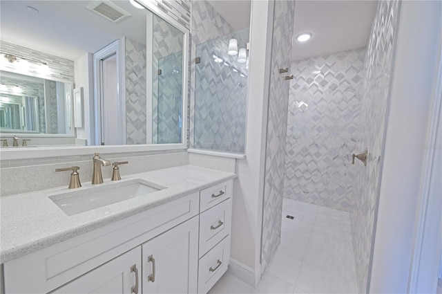 bathroom with tile patterned flooring, visible vents, vanity, and walk in shower