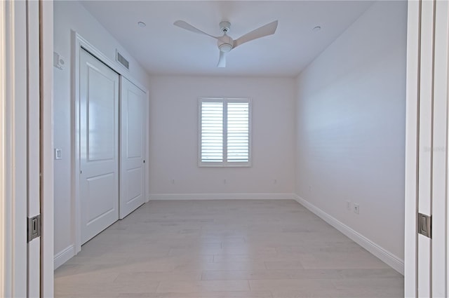 unfurnished bedroom with baseboards, visible vents, a ceiling fan, light wood-type flooring, and a closet