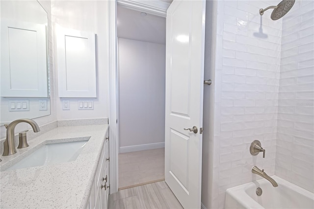 bathroom with tub / shower combination, ceiling fan, and vanity