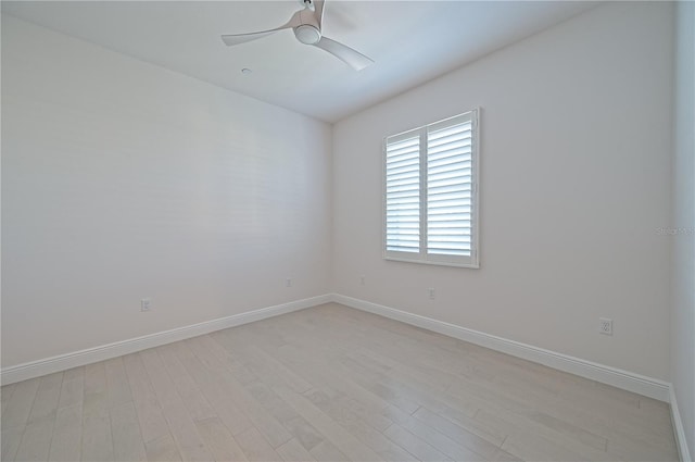 empty room featuring light wood finished floors, a ceiling fan, and baseboards