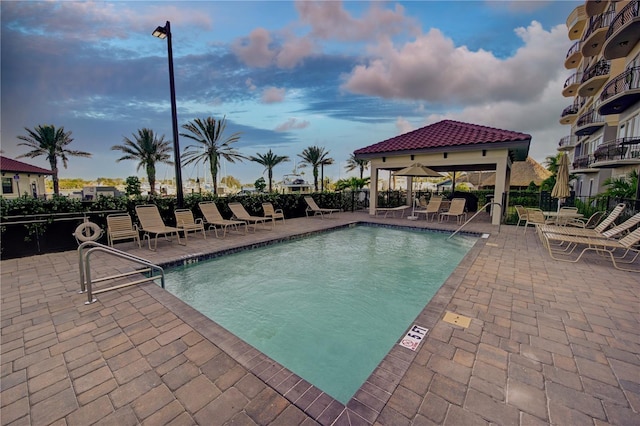 pool featuring a gazebo, a patio area, and fence