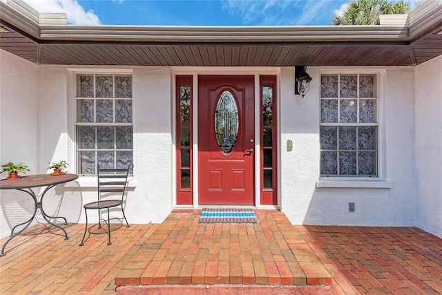 property entrance featuring crawl space, a porch, and stucco siding