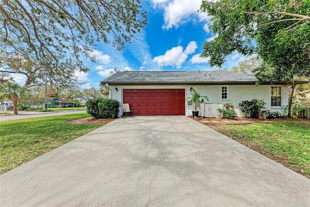 view of front of property featuring a front lawn, driveway, an attached garage, and stucco siding