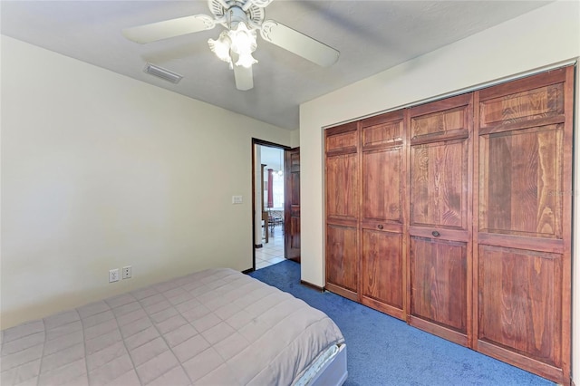 unfurnished bedroom featuring carpet, a closet, visible vents, and ceiling fan