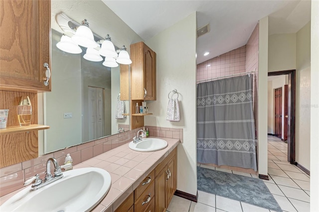 full bathroom with double vanity, visible vents, a sink, and tile patterned floors